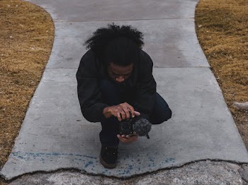 Man Crouching Holding Camera