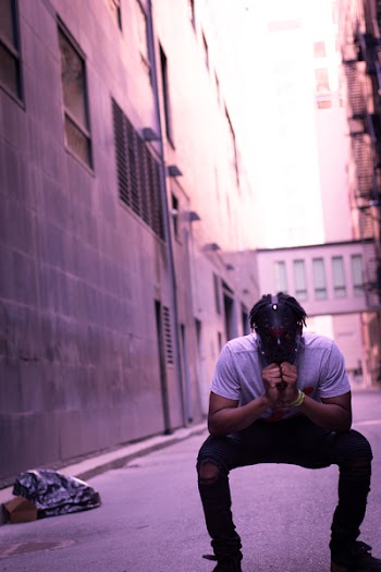 Man Crouching Near Building Wall Outdoor