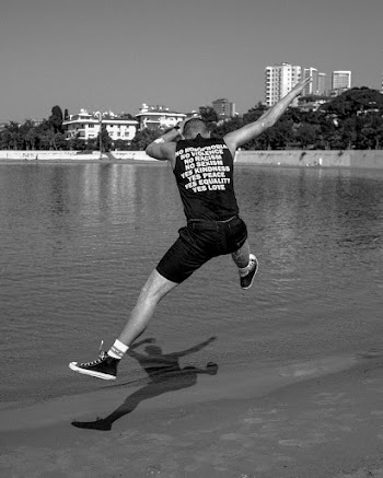 Man Dabbing in Mid Air Above Body of Water during Day