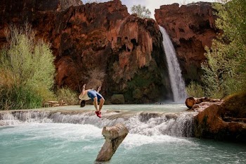 man diving on water near falls