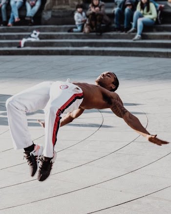 man doing acrobat trick in front of people