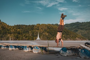 Man Doing Handstand on Wooden Planks