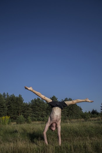 Man Doing Handstand pose on Green Grass Field
