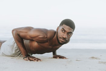 Man Doing Push-ups on Sand