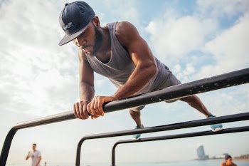 Man Doing Pushups on Bars
