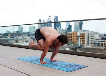 Man Doing Yoga on Mat Near Glass Balcony Fence