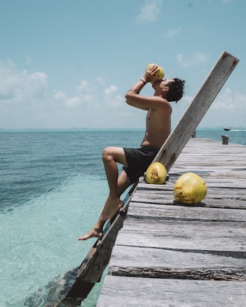 Man Drinking from Coconut