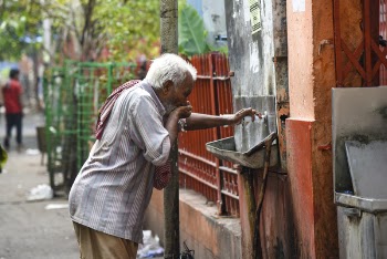 Man Drinking Water from Drinking Fountain