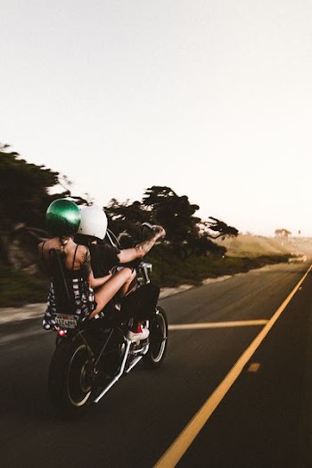 man driving on motorcycle with woman