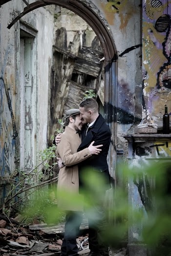 Man Embracing Man Near Gray Wall