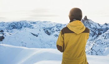 man facing snow covered mountain