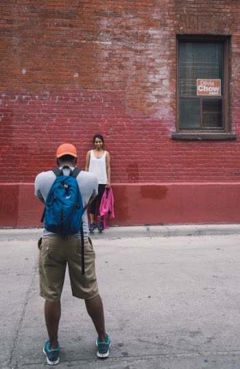 Man Facing Woman Leaning on Bricked Building Wall