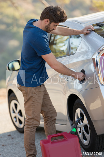 Man filling car gas tank at roadside