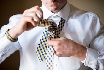 Man Fixing His Necktie in Close-up Photography