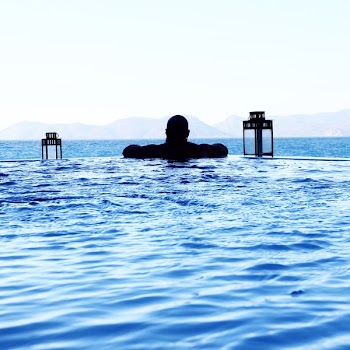 Man Floating on Pool in Front of Sea