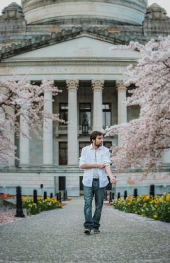Man Folding Left Sleeved Dress Shirt Near White Dome Building