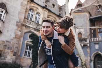 Man Giving a Woman a Back Ride Near Building