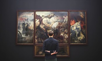 man hands on back looking on painting mounted at wall