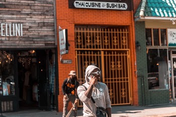 Man Having a Call Near Metal Gate