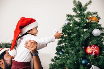 Man Helps Toddler Decorate Christmas Tree