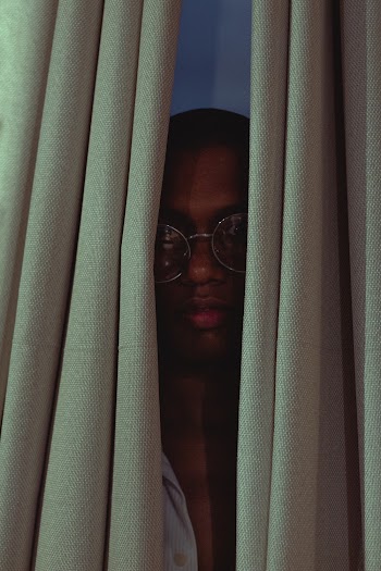 Man Hiding Behind Curtain
