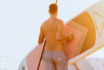 Man Holding a Paddleboard