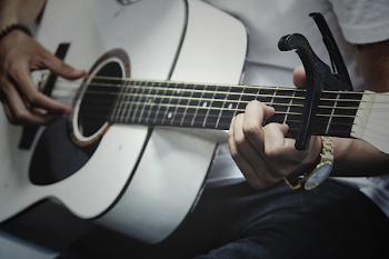 Man Holding a White Dreadnought Acoustic Guitar
