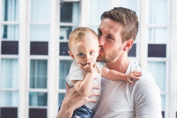 Man Holding and Kissing Baby