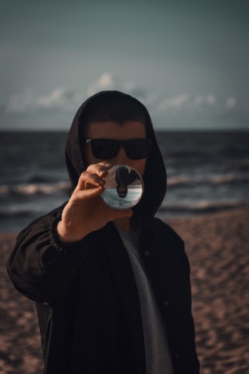 Man Holding Baoding Ball Near Seashore
