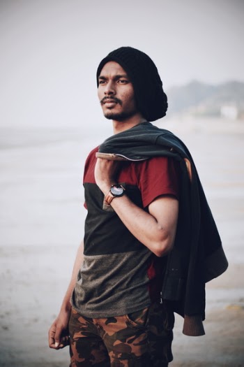 Man Holding Black Apparel Standing Near Body of Water