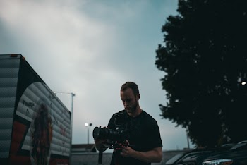 Man Holding Black Dslr Camera