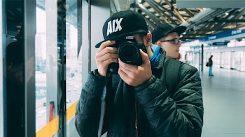 Man Holding Black Dslr Camera