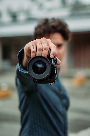 Man Holding Black Dslr Camera