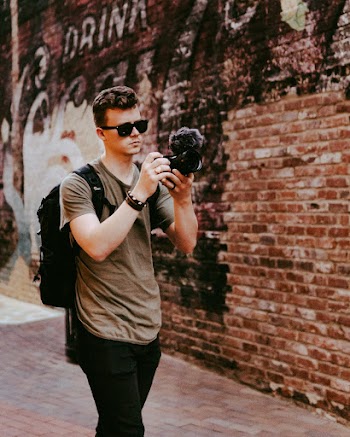 Man Holding Black Dslr Camera
