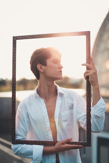 Man Holding Black Frame in Front of His Face