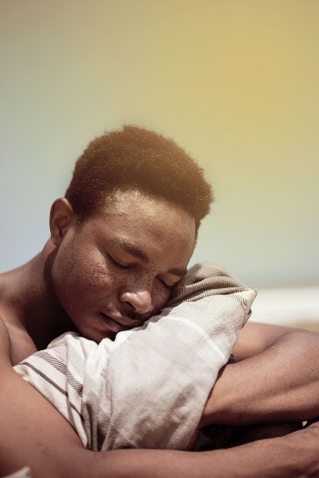 Man Holding Blanket with His Eyes Closed