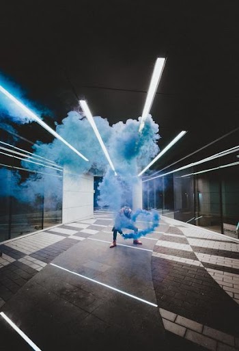 man holding blue smoke canister
