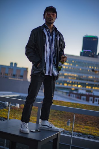 Man Holding Bottle Standing on Desk on Deck