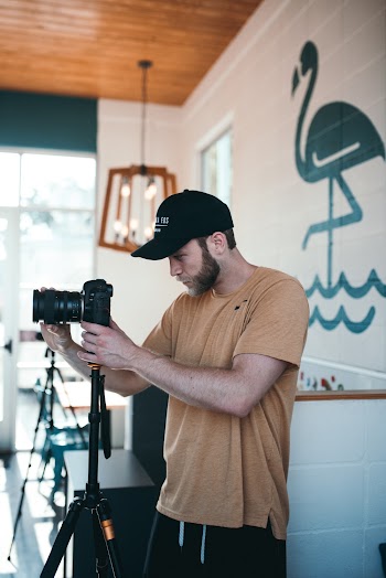 Man Holding Camera in Room