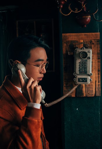 Man Holding Grey Cradle Telephone