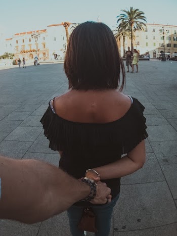 Man Holding Hand of Woman Showing Back