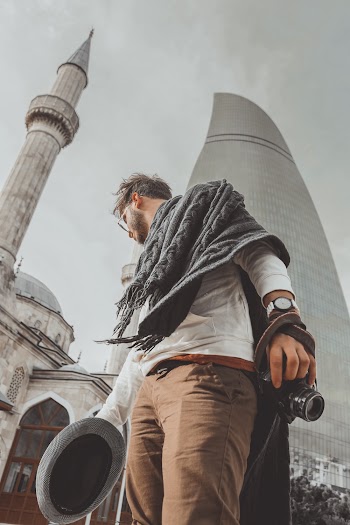 Man Holding Hat and Camera