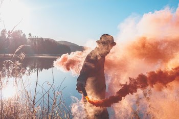 man holding lighted red flare