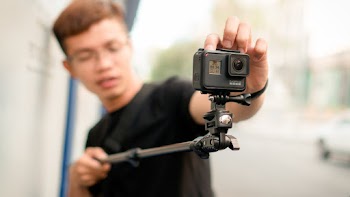 Man Holding Monopod With Action Camera