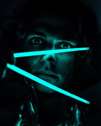man Holding Neon Light Sticks Inside Dark Room