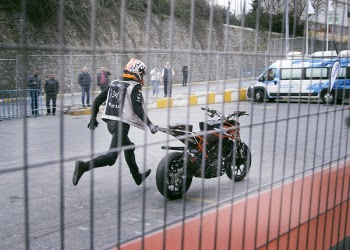 Man Holding Orange and Black Sports Bike on Asphalt Road