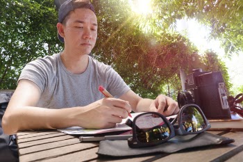 Man Holding Pen and Paper