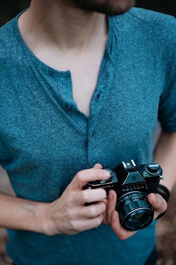 man holding Pentax SLR camera