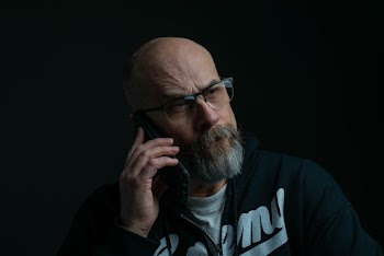 Man Holding Phone And Wearing Eyeglasses