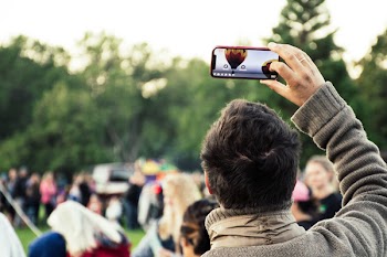 Man Holding Phone Capturing Hot Air Balloon